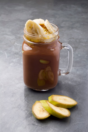 35156916 - fresh chocolate and banana smoothie on a gray vintage table